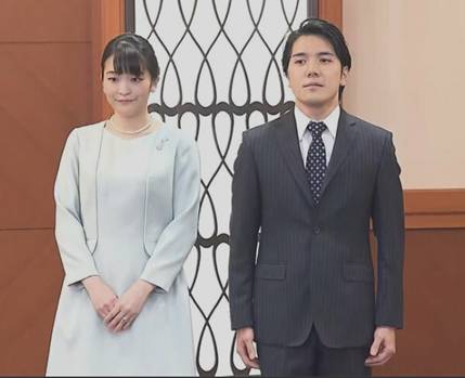 白い壁の前に立つスーツを着た男性たち低い精度で自動的に生成された説明